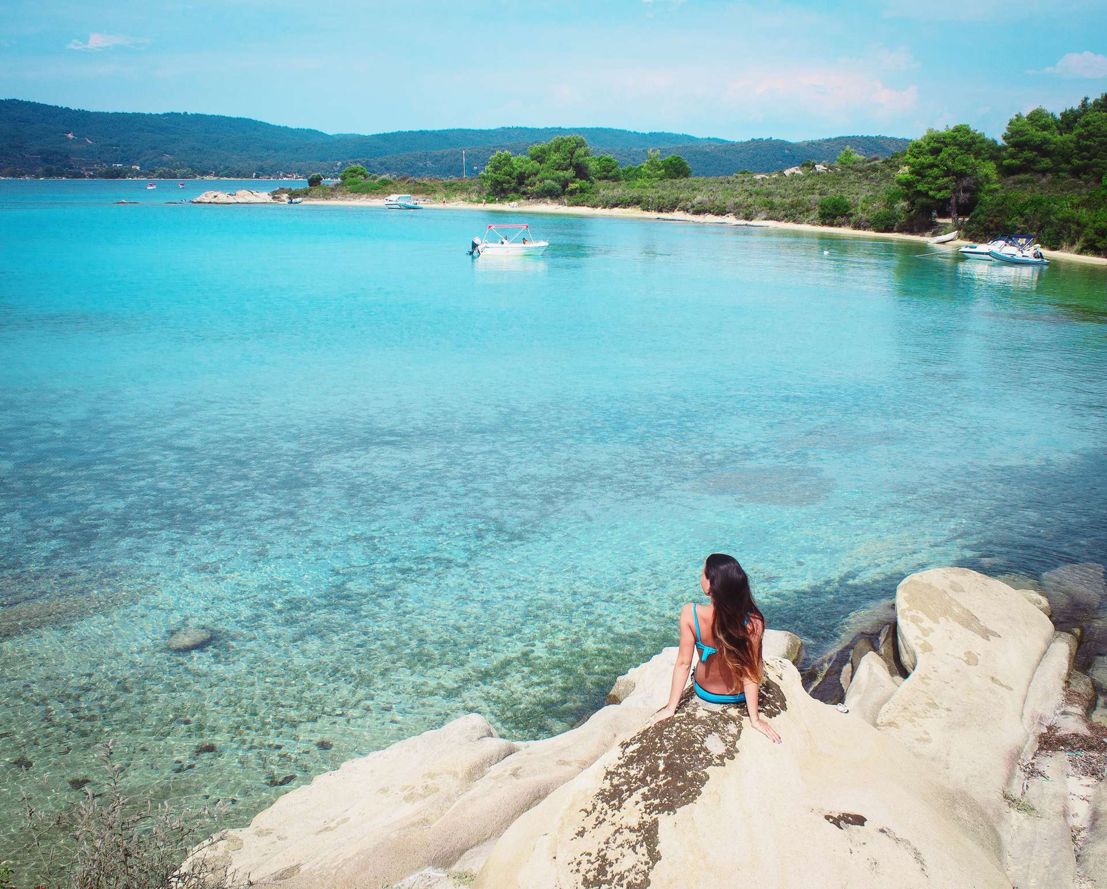 Griekenland Chalkidiki vrouw zit op rotsen